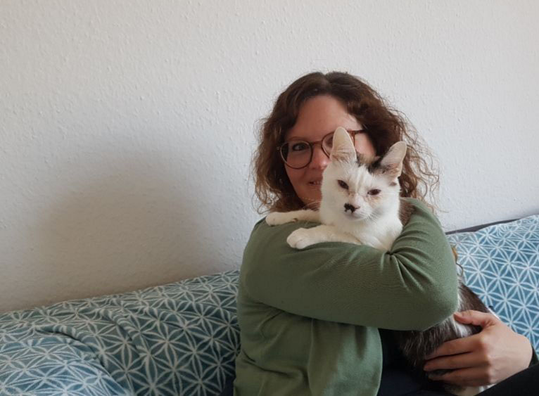 Sandra B. and cat Mamitzki. Favourite activities: enjoying extensive cuddles, hiding in cupboards and lying in the sun.  Don't go: noisy visitors, hoovers, rayon ban on the desk.